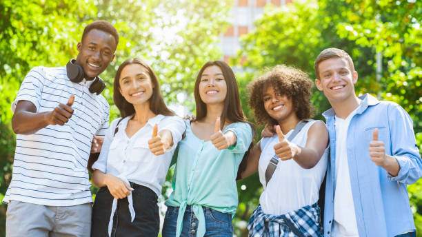 istock Multicultural Teen Friends Posing At Camera Outdoors And Gesturing Thumb Up 1211950062