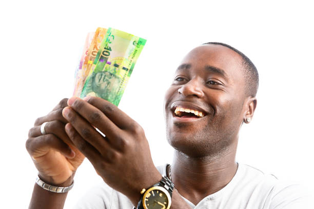 アフリカ人男性が南アフリカの紙幣を持ち、楽しそうに微笑む。 - ten rand note ストックフォトと画像