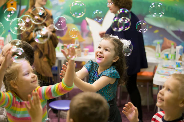 istock Soap bubbles show. Children's party. To burst the soap bub 1211952644