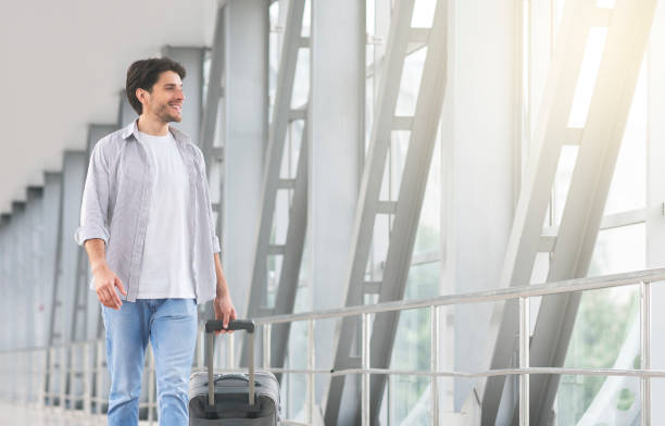 istock Handsome Young Guy With Suitcase Walking In Terminal, Going To Gate 1211954361