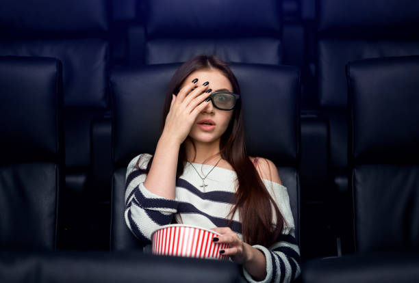 coming to movies alone. scared young lady watching 3d horror film in cinema - audience surprise movie theater shock imagens e fotografias de stock