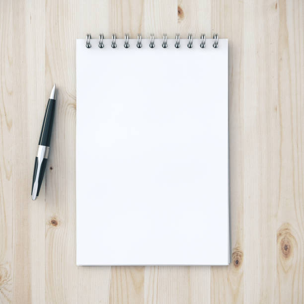 istock Office wooden desk table with note pad and pen 1211955400