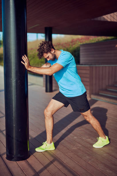 istock Young man exercising / stretching in urban area. 1211955818