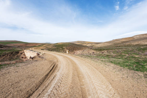 istock Country dirt road in mountains valley 1211960452