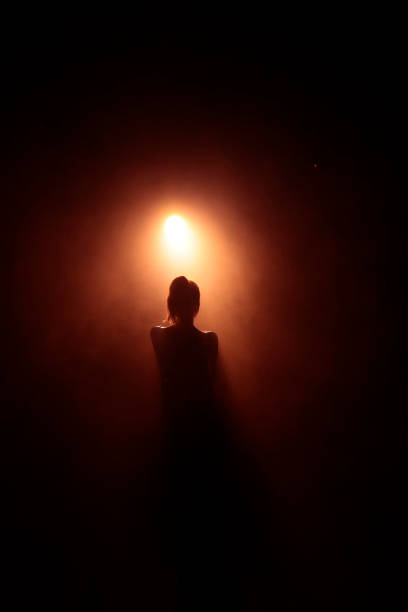 istock Girl looking at a spotlight in the dark 1211961145