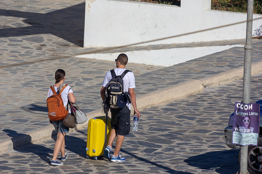 A young Caucasian couple walking through the Mykonos Harbour area in the early hours