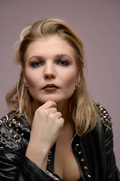 istock Woman blonde in leather jacket looking at camera isolated in studio 1211962377