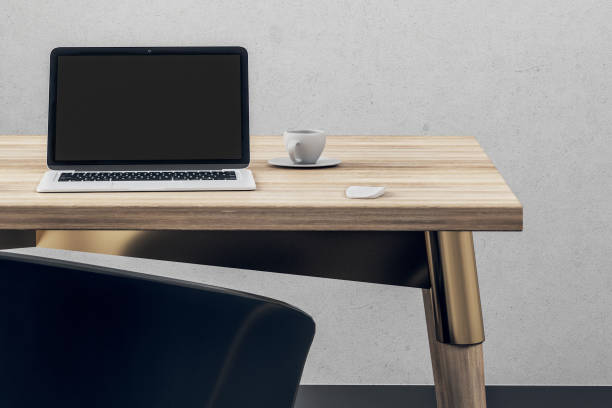 istock Minimalistic office with blank black laptop screen 1211962576