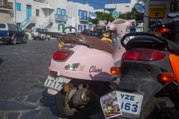 Motor Scooters in Mykonos Town, Greece, with number plates visible and incidental people