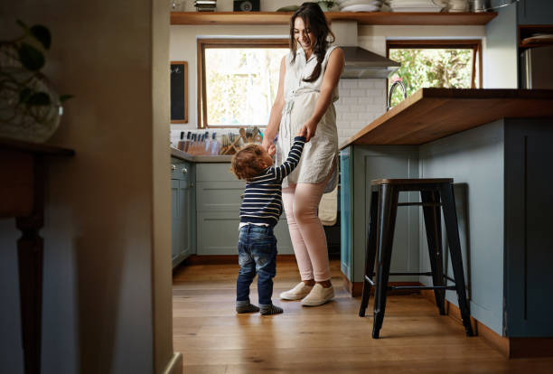 Our kitchen is for dancing Shot of a young woman spending quality time with her adorable child at home baby boy dancing with his mommy stock pictures, royalty-free photos & images