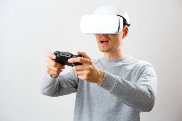istock Man with virtual reality headset is playing game. 1211963914