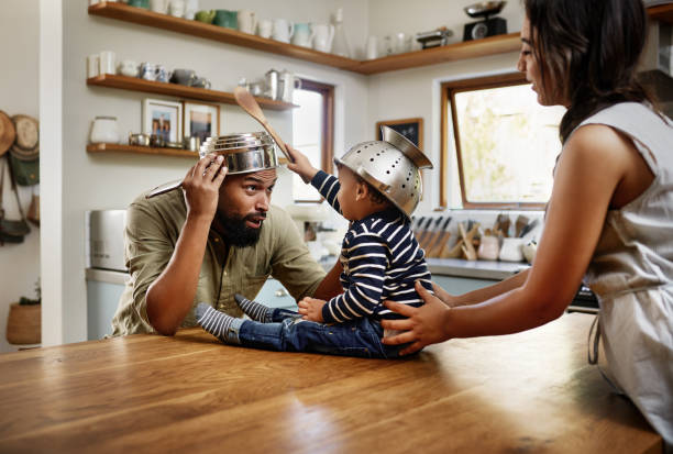 Happy hearts, happy home Shot of an adorable young family having fun with pots and pans in the kitchen toddler hitting stock pictures, royalty-free photos & images