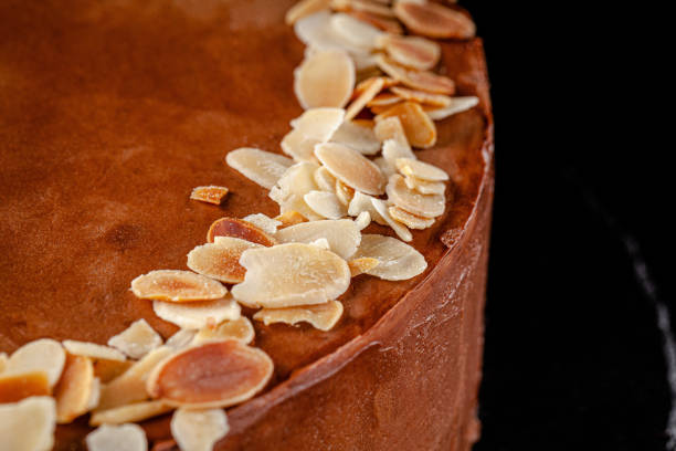 istock Modern pastry. Chocolate cake with nuts, almonds and peanut butter. Cake on a black background. background image, copy space text 1211965518