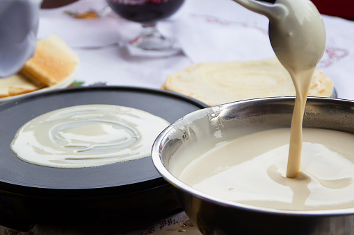 Cooking pancakes.Pour dough for pancakes into a frying pan