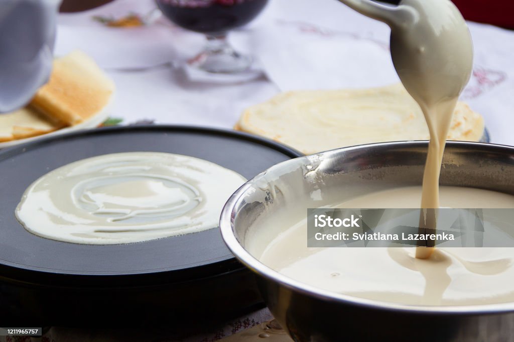 Cooking pancakes.Pour dough for pancakes into a frying pan Crêpe - Pancake Stock Photo
