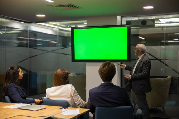 istock Confident mature speaker talking and pointing at display 1211965942