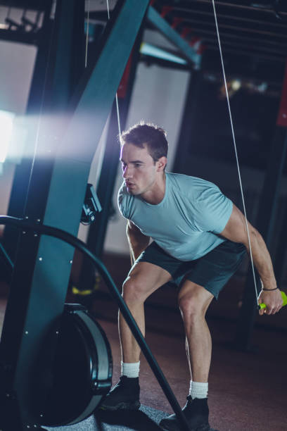 istock Athletic male doing upper body work out on cable machine 1211966850