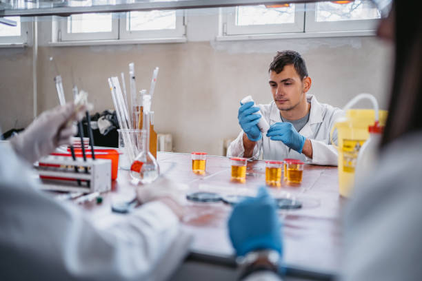 practitioner measuring ph test strips of urine sample - doping imagens e fotografias de stock