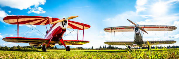 An old white biplane in the air.