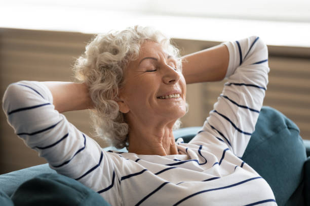 istock Happy elderly woman relax sleeping on cozy sofa 1211971835