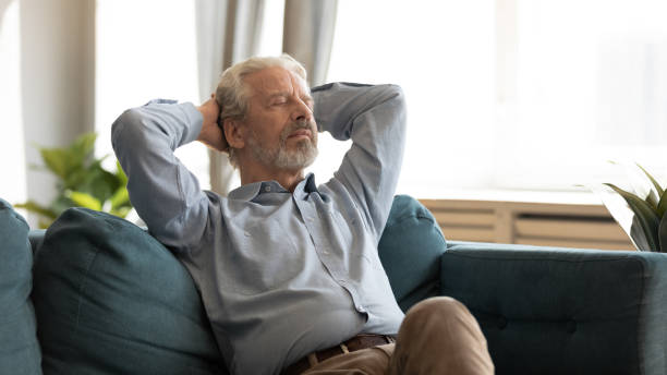 istock Elderly 60a husband rest on cozy couch at home 1211971840
