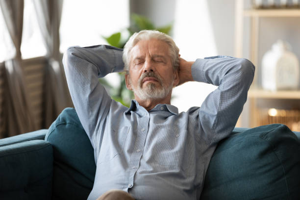 istock Peaceful 60s old man relax on couch in living room 1211971842