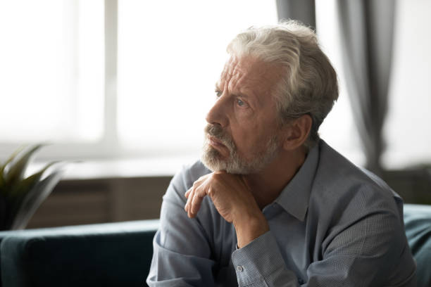 istock Depressed elderly man lost in thoughts mourning at home 1211971848