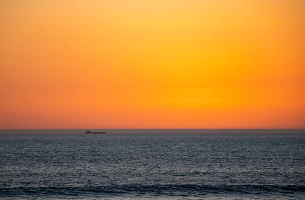Ship on sunset horizon at Taghazout, Morocco. With the sun disappeared over the horizon.