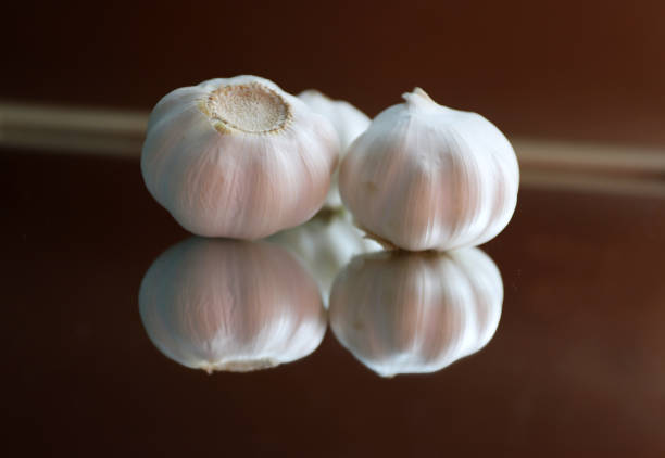 Garlic bulbs and garlic cloves on a mirror. Selective focus.