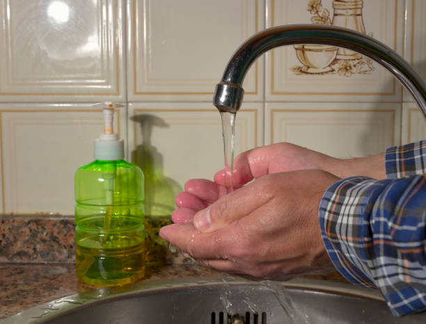 istock Man washing hands with soap and water 1211974119