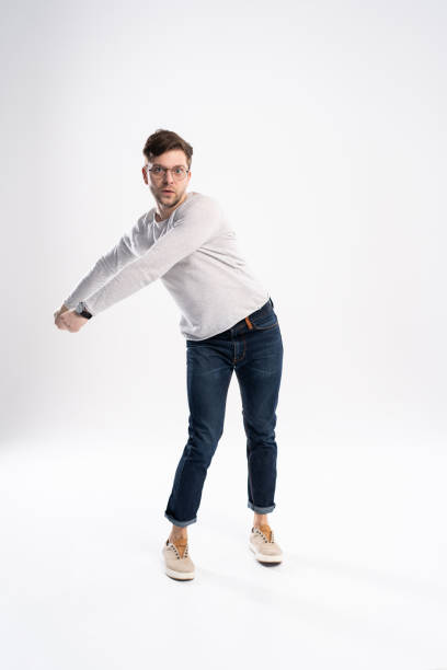 istock Funny man in casual is having some fun. He is posing and dancing. Isolated on white background. 1211974241