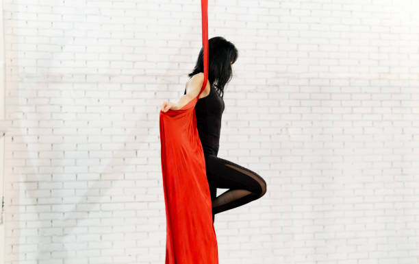 istock beautiful woman doing aerial dance with fabrics 1211974954