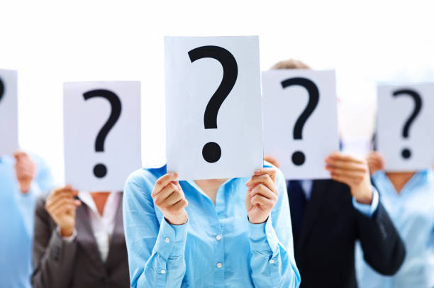 Colleagues holding question mark signs in front of their faces  mystery stock pictures, royalty-free photos & images