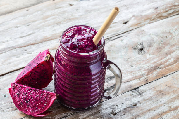 istock Fresh smoothie juice from a Dragon fruit (pitahaya) in a glass jar, fruit slices on old rustic table with copyspace. 1211980053