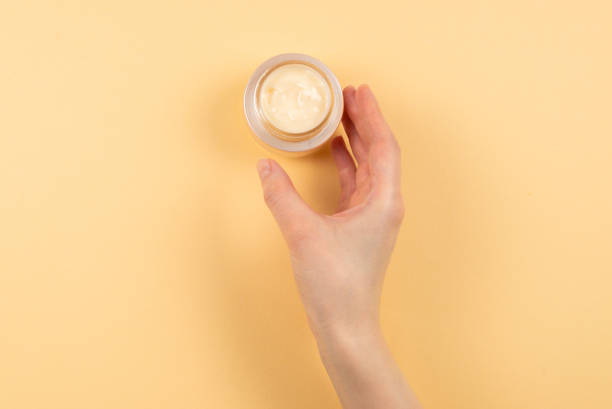 istock Hand cream and woman hands on a beige background. 1211980195