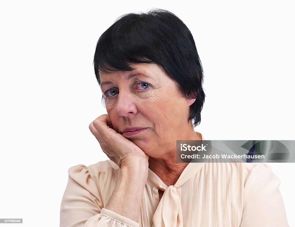 Senior donna con le mani sul mento contro bianco - Foto stock royalty-free di 65-69 anni