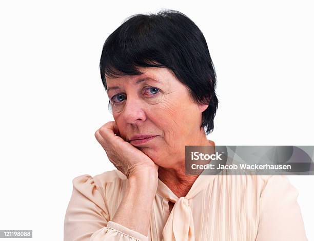 Senior Donna Con Le Mani Sul Mento Contro Bianco - Fotografie stock e altre immagini di 65-69 anni - 65-69 anni, Abbigliamento casual, Adulto