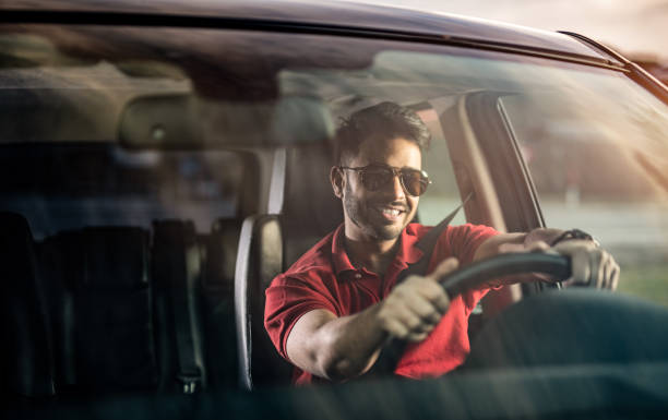 Middle Eastern Man Driving a Car. Middle Eastern man having a good time driving his car. happy car asian stock pictures, royalty-free photos & images