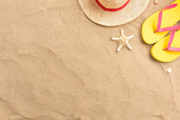 istock Flip flops, straw hat, on sand background. Beach vacation concept .Top view with copy space. 1211981431