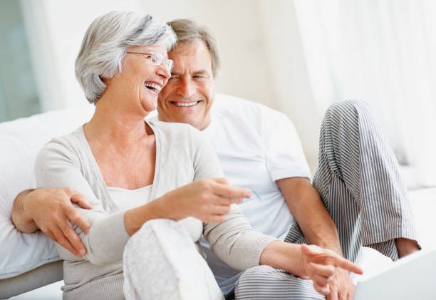 istock Excited retired couple using a laptop at home 121198177