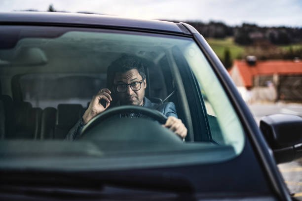 istock Middle Eastern Businessman Driving A Car and Talking on Phone. 1211981842
