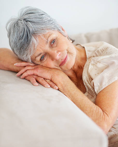 istock Retired senior lady relaxing on couch 121198276