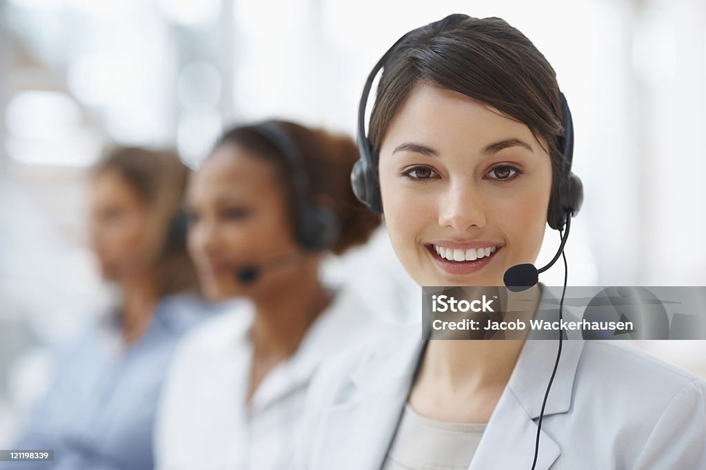 Primer plano de un centro de llamadas empleado con auriculares en lugar de trabajo - Foto de stock de Agente de servicio al cliente libre de derechos