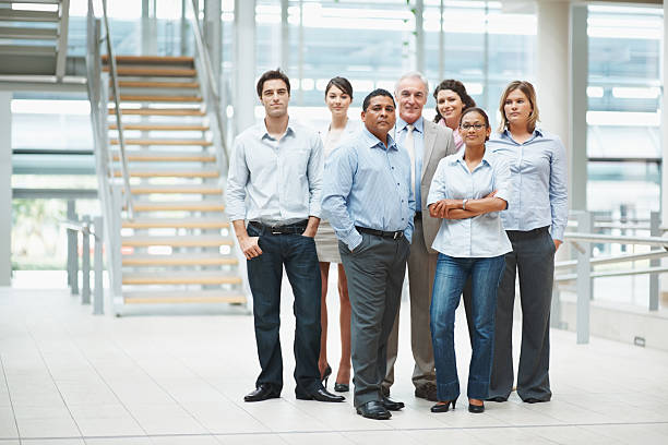 istock Confident business people standing together in group at office 121198592
