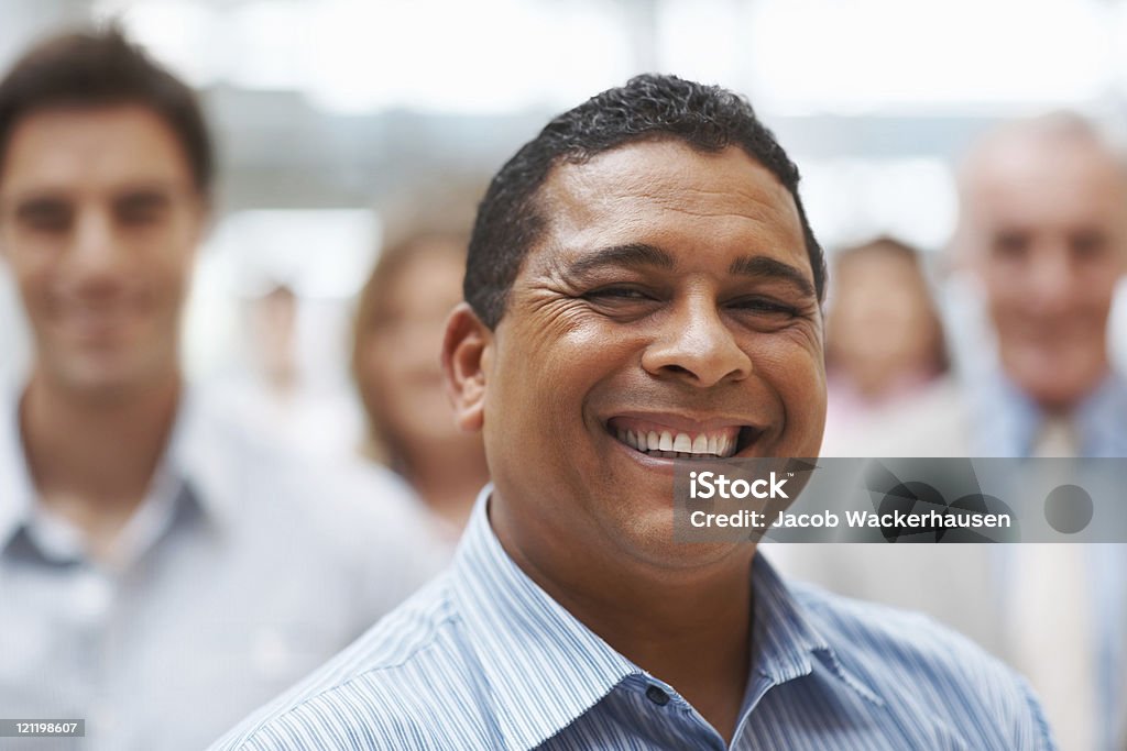 Maturo Uomo d'affari felice sorridente con i colleghi nella parte posteriore - Foto stock royalty-free di Abbigliamento elegante