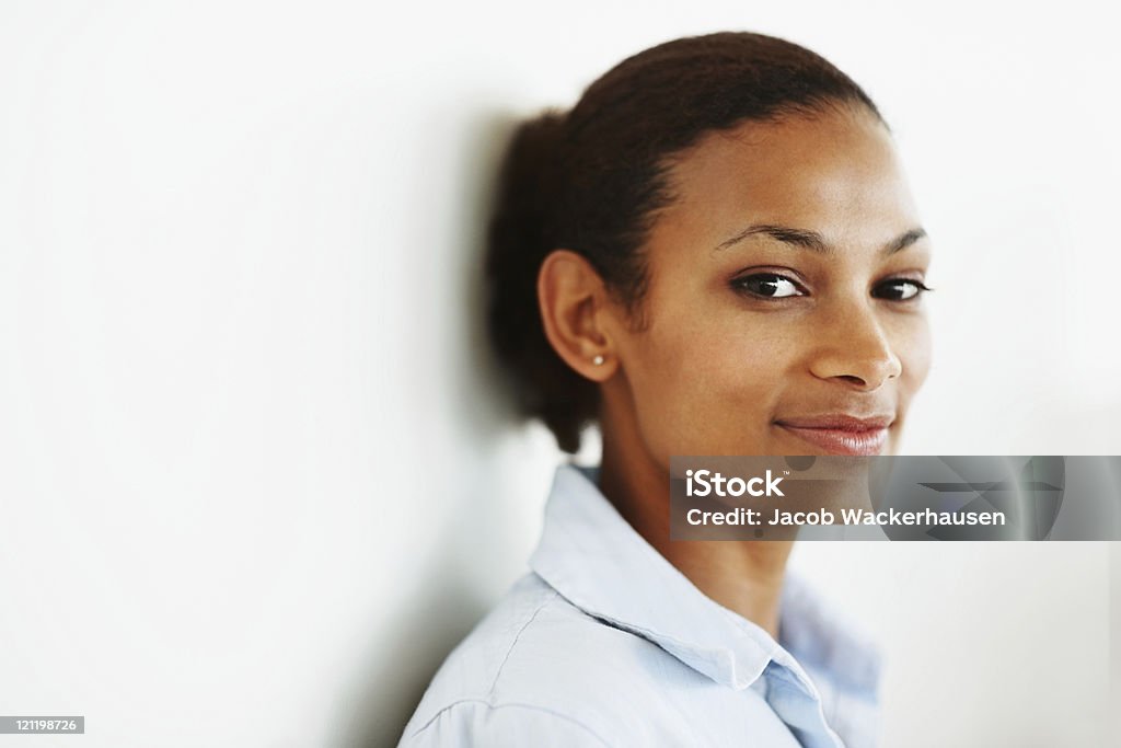 Симпатичная Молодая женщина, улыбающаяся против белой стене - Стоковые фото Белый фон роялти-фри