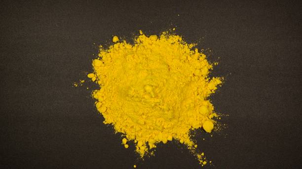 istock TOP VIEW: Pile of Curcuma powder on a black table 1211987833