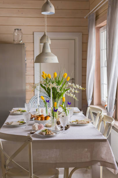 istock Easter festive spring table setting decoration, eggs in nest, fresh yellow tulips, marshmallows, selective focus 1211990105