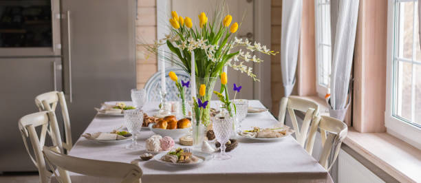 istock Easter festive spring table setting decoration, eggs in nest, fresh yellow tulips, marshmallows, selective focus banner 1211990115