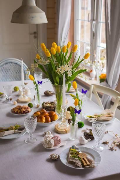 istock Easter festive spring table setting decoration, eggs in nest, fresh yellow tulips, marshmallows, selective focus 1211990121
